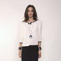 Arina - Blusa em malha manga comprida na cor off-white com debrum preto