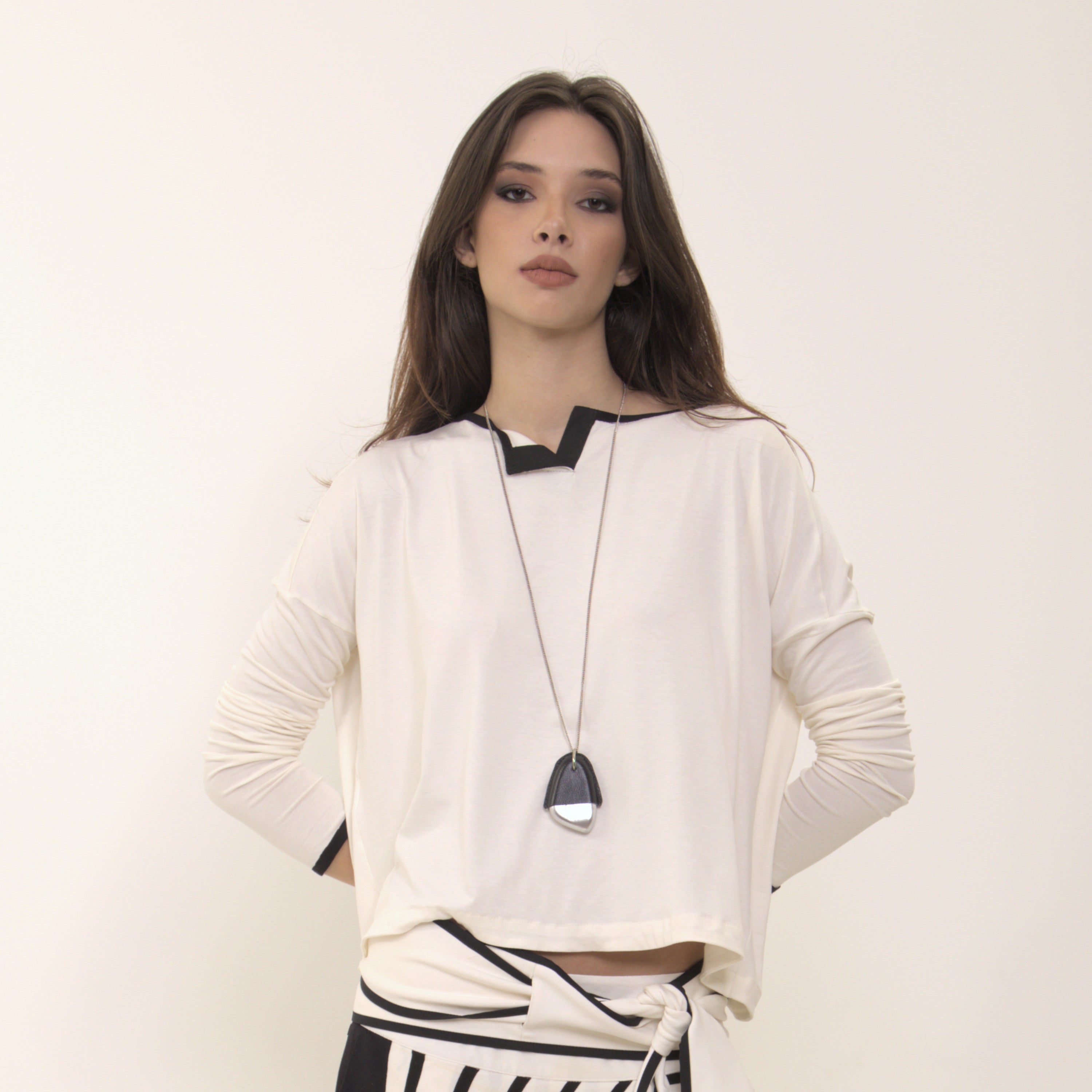 Arina - Blusa em malha manga comprida na cor off-white com debrum preto